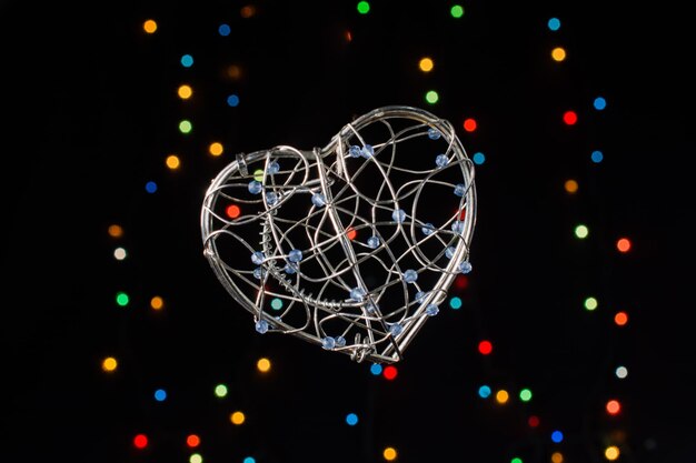 Photo heart shaped metal cage on a bokeh light background