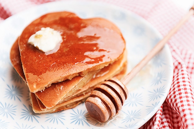 Heart shaped pancakes on a light background. the concept of a festive breakfast for Valentine's Day or a pleasant surprise for a loved one