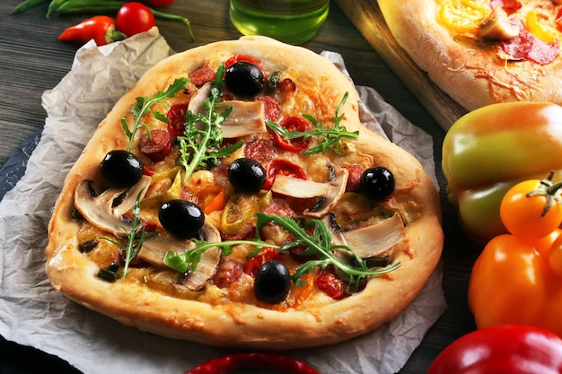 Heart shaped pizza on craft paper on wooden table