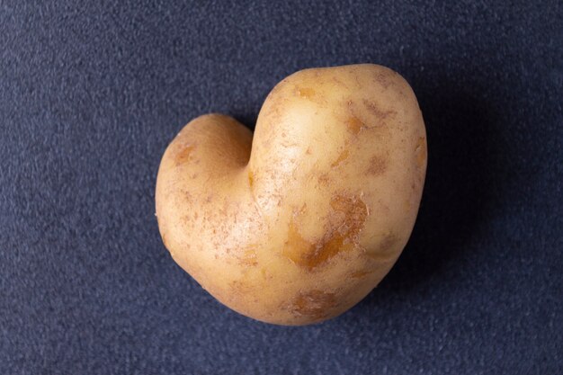 heart shaped potatoes on blue background close up