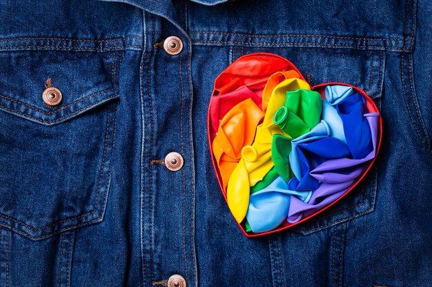 Bandiera lgbtq arcobaleno a forma di cuore contro il mese dell'orgoglio sullo sfondo del denim