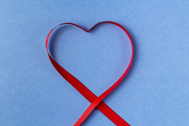 Heart shaped ribbon on a blue background.