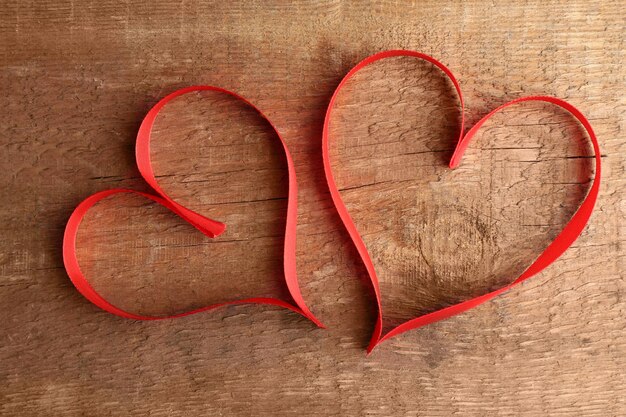 Heart shaped ribbon on wooden background