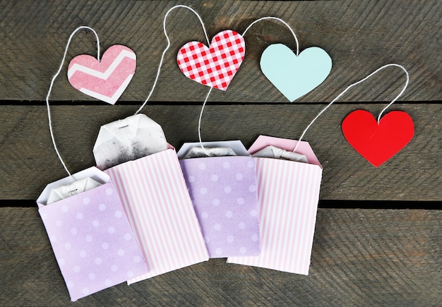 Heart shaped teabag tags on wooden background