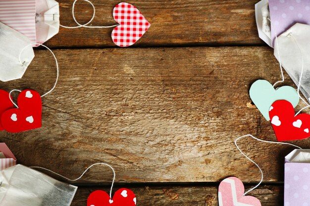 Heart shaped teabag tags on wooden background