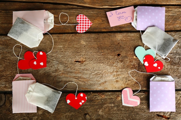 Heart shaped teabag tags on wooden background