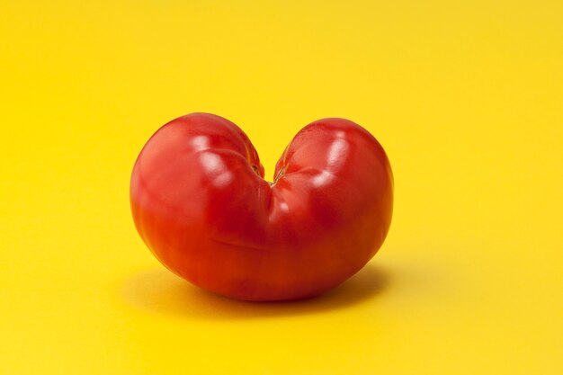 사진 심장 모양의 노란색 배경에 토마토 재미있는 야채