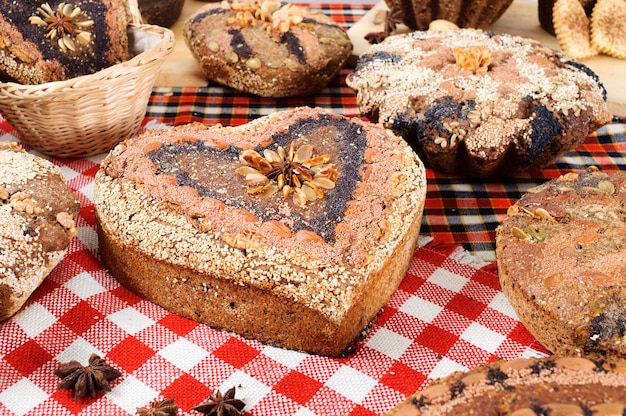 Heart shaped traditional bread lying on cellular tablecloth.