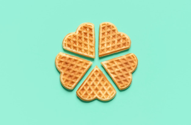 Heart shaped waffles top view on a green table Belgian waffles isolated on a colored background