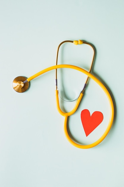 A heart on a stethoscope is placed on a blue background.