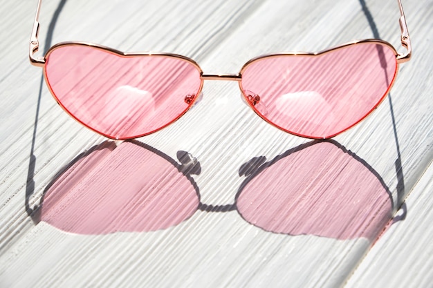 Heart sunglasses on white wooden table