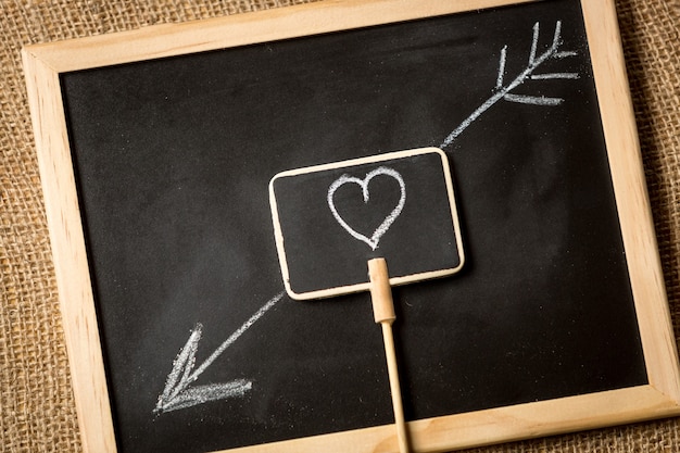 heart with arrow drawn by chalk on blackboard