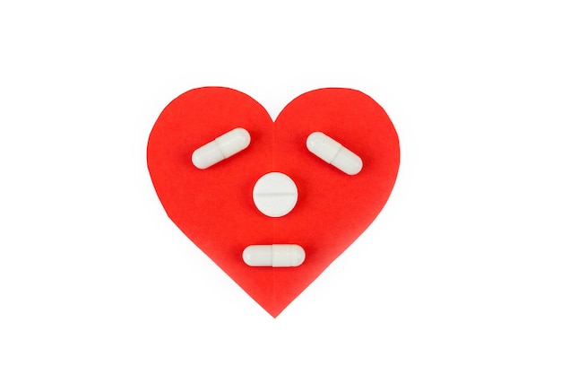 Heart with eyes, nose and mouth from pills on a white background. The concept of prevention and treatment of heart disease.