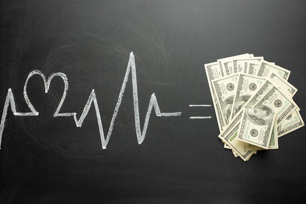 Диаграмма сердцебиения на доске, равная денежной концепции дорогого медицинского страхования, дорогого отсутствия денег на лечение