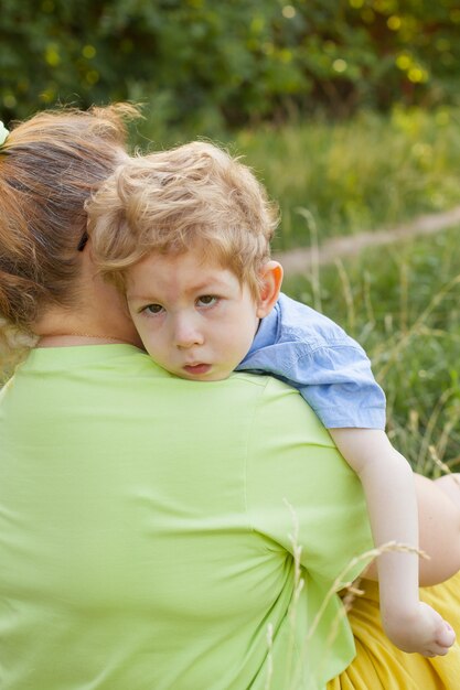 A heartfelt moment. portrait of a mother and her beloved son of European appearance with disabilities in a park on a summer day. Disability. Mother's love.