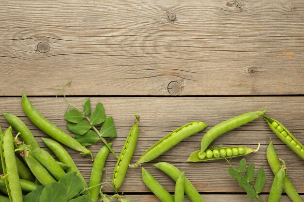 Hearthy fresh green peas on rustic wooden background with copy space