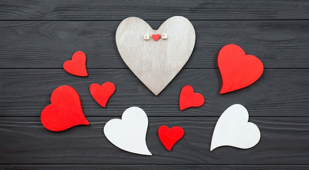 Hearts are laid out on a dark wooden background.