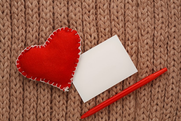 Foto cuori tagliati da tessuto su un filo, su uno sfondo a maglia. carta di san valentino