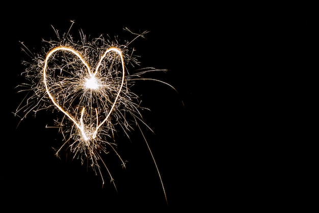 Hearts on a dark background drawn by a sparkler