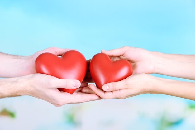 Hearts in hands on cloud background