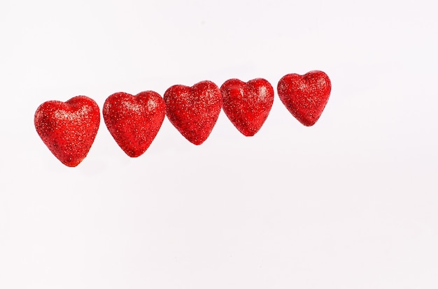 Hearts red glittering for Valentine's Day on a shiny background