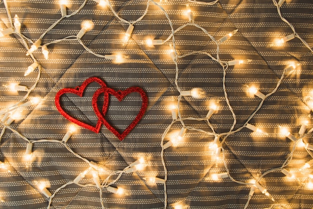 Hearts with garland lights over cozy plaid