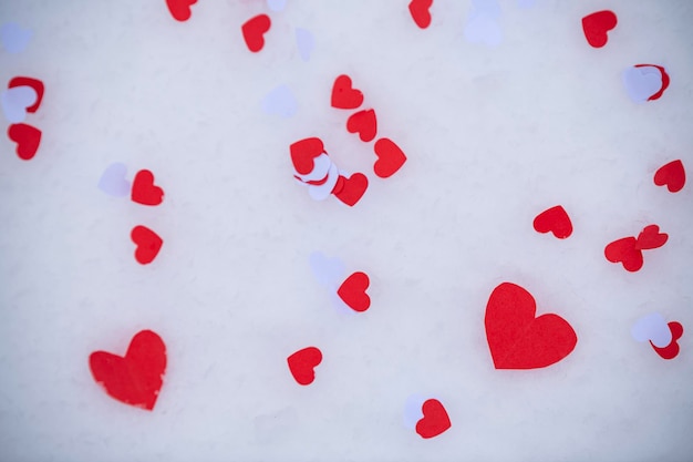 Heartshaped confetti lying on the snow