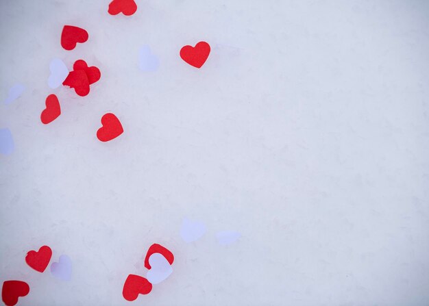 Coriandoli a forma di cuore sdraiati sulla neve