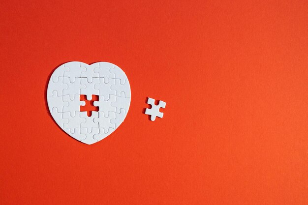 Heartshaped jigsaw puzzle on color background