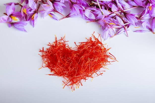 Photo heartshaped saffron threads on a white background