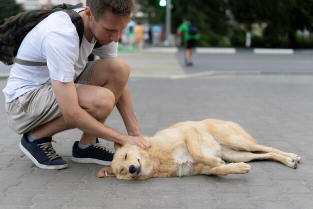 A Heartwarming Moment A Man Kneeling Down Next to a Brown Dog