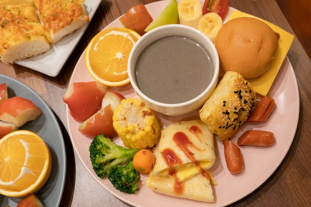 Abbondante colazione con pane e frutta nel piatto di casa