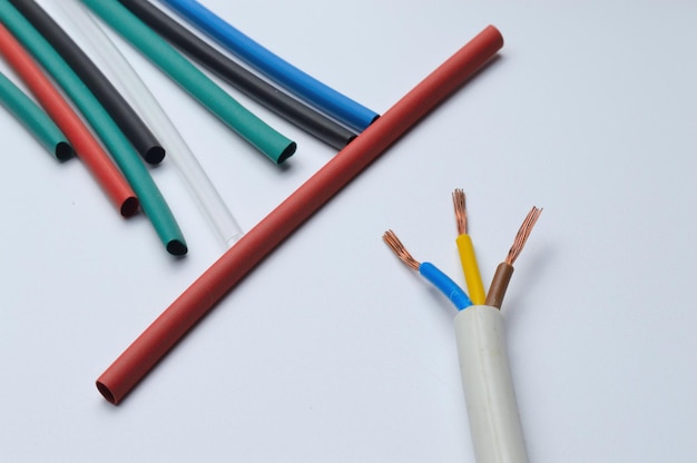 heat shrink tubing and a three-core stripped wire on a white background.