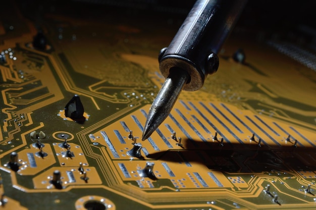 a heated soldering iron solders a small contact on the chip.