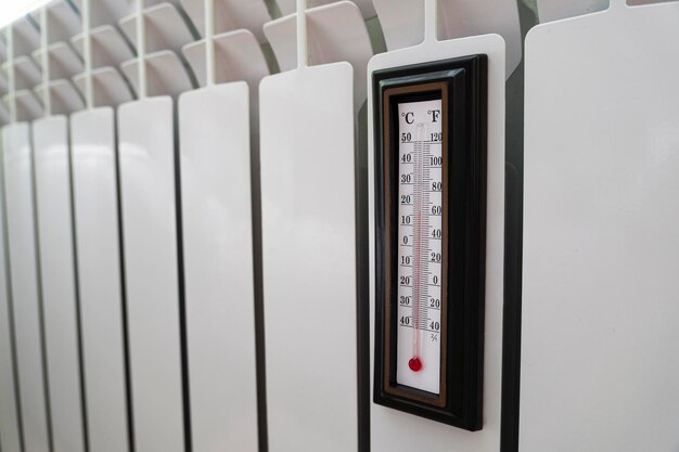 heating radiator thermostat set to low temperature and room thermometer for saving money at heating costs energy crisis energy efficiency and rising heating costs in europe 17 degrees celsius