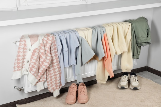 Heating radiator with clothes and shoes in room