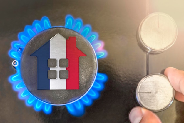 Heating season or gas use in France Concept model of a house stands near the flame of a gas boiler on a black background The cost of using natural gas in France