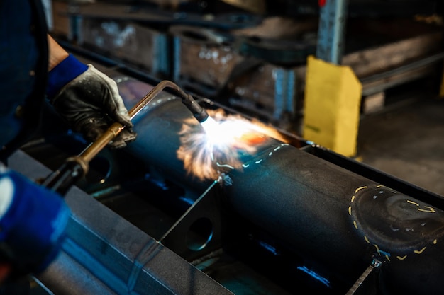 Foto riscaldamento di costruzioni metalliche con bruciatore di acetilene e ossigeno nel processo di raddrizzazione a fiamma con colore rosso visibile del metallo riscaldato