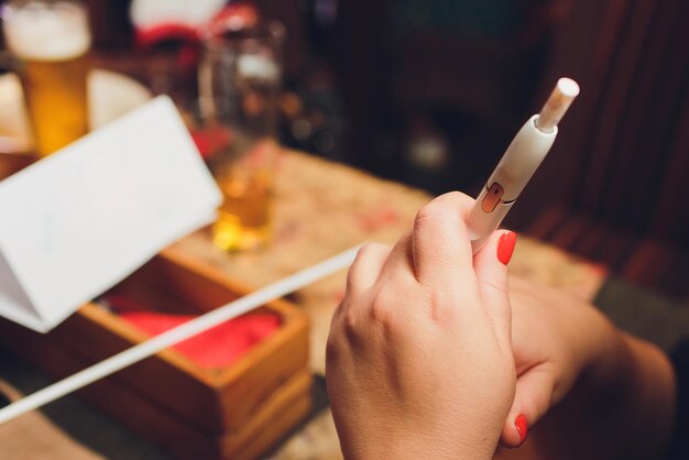 heatnotburn tabaksproducttechnologie vrouw die een e-sigaret in zijn hand houdt voordat ze gaat roken