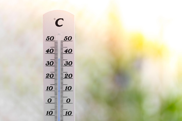 ぼやけた背景の熱で夏の熱波温度計