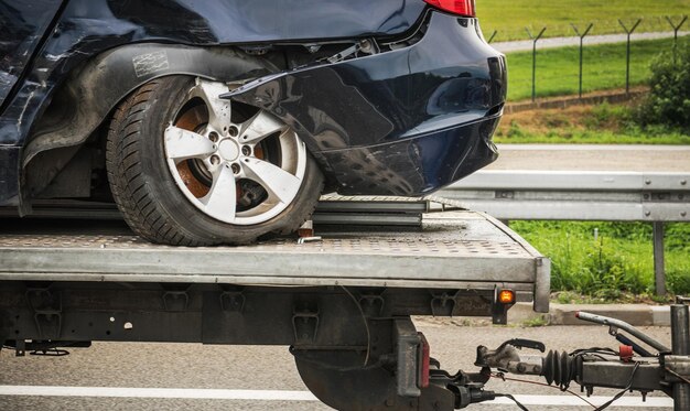 Photo heavily damaged car shipped on trailer to body shop