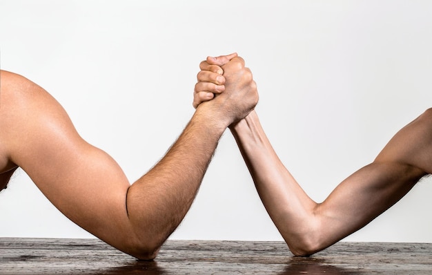 Foto un uomo muscoloso che lotta a braccio con un uomo debole e insignificante due mani di uomini strette a braccio che lottano forte e debole ineguale partita