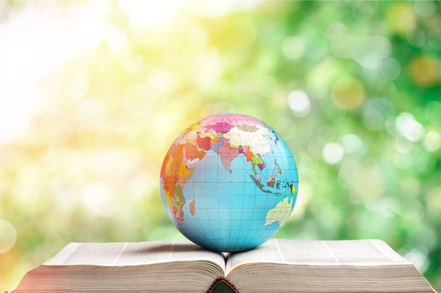 Heavy book and globe on background