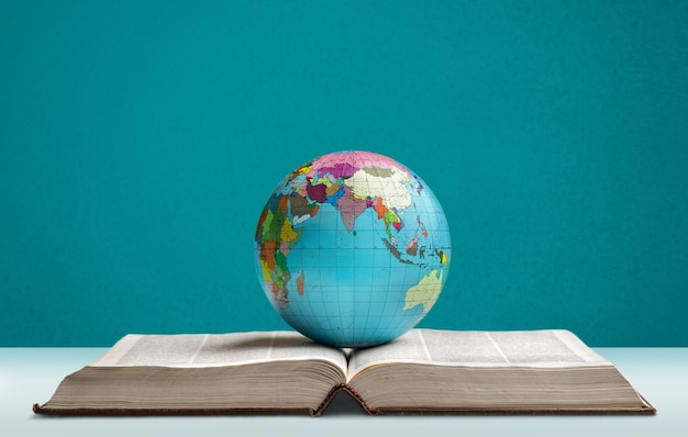 Photo heavy book and globe of a planet on the desk