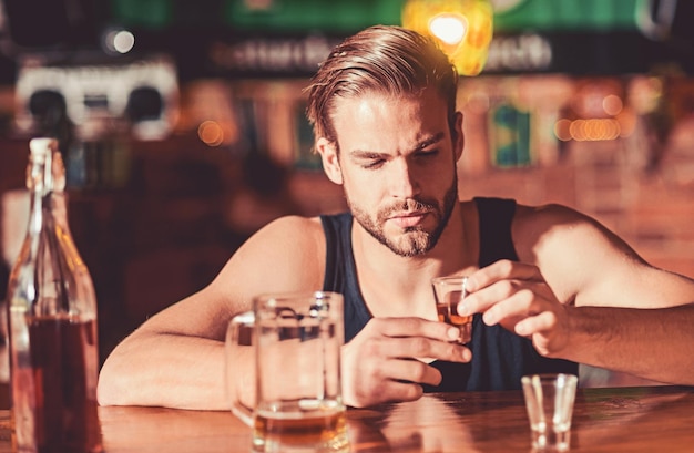 Bere pesante fa male l'alcolista che beve al bancone del bar l'uomo beve una forte bevanda alcolica e birra al pub alcooldipendente con una breve bevanda alcolica dipendenza da alcol bere alcol