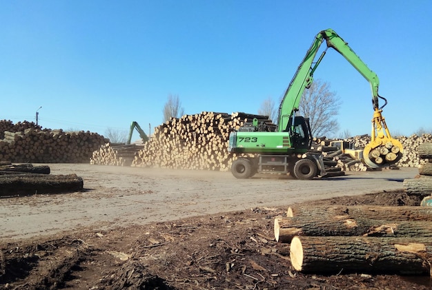 Heavy duty green claw like logging machine for picking up and\
piling logs