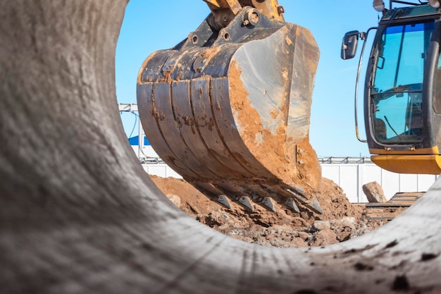 Heavy excavator at the construction site View of the excavator through the iron pipe Construction equipment for earthworks Quarry excavator