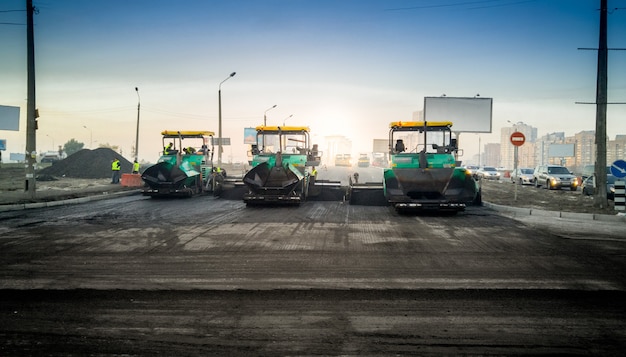 Heavy industrial machines laying asphalt on new road