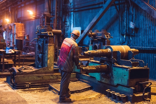 Lavoratore dell'industria pesante che lavora duro sulla macchina. ambiente industriale approssimativo.