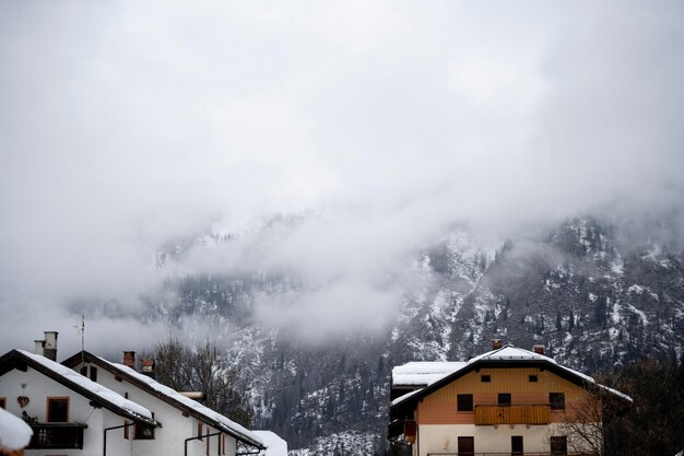 Foto pesanti nuvole di neve incombono sulle montagne innevate e sugli abeti nel piccolo villaggio turistico di montagna